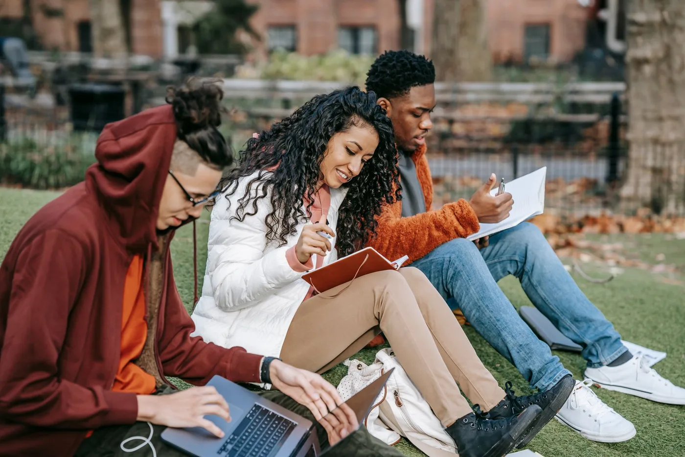 Three students working together outdoors on campus